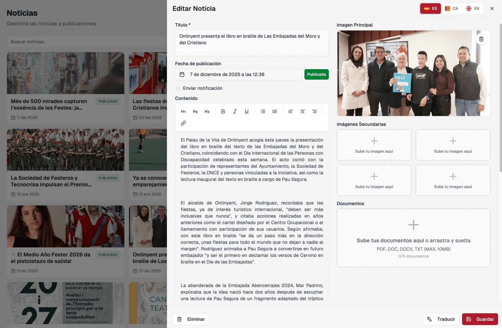 Edición de una noticia en el panel: título, fecha de publicación, aviso al móvil, contenido con formato, imagen principal, imágenes secundarias y documentos, con el selector de idioma